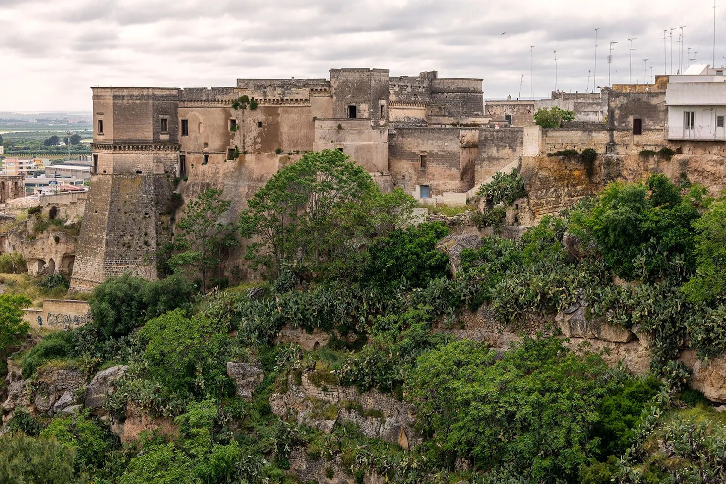 Il castello di Massafra con i suoi bastioni affacciato sulla gravina, tra la vegetazione e le rocce